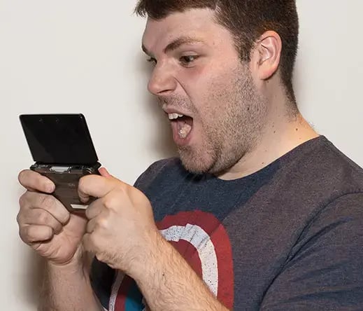 Photo d'Alexandre jouant avec enthousiasme à un jeu vidéo
