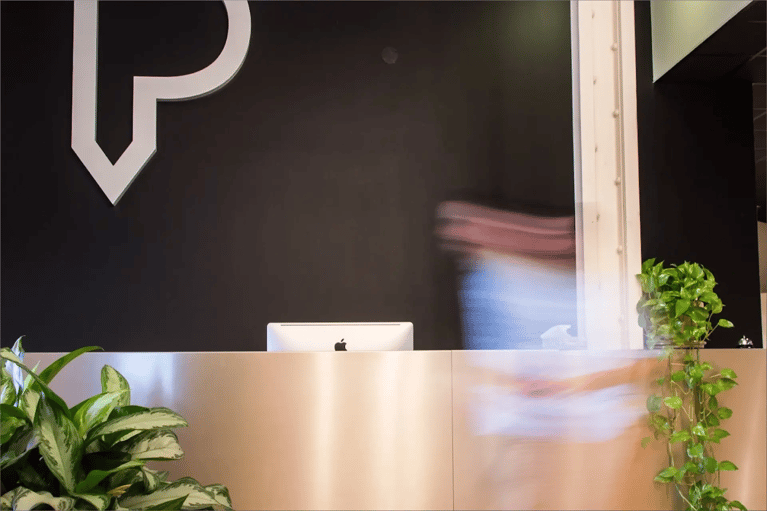 Personne en mouvement devant un bureau faisant face au logo de Parkour3 grand format