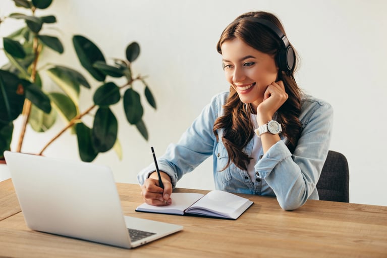 Portrait d'une jeune femme souriante avec des écouteurs participant à une formation dans un bureau