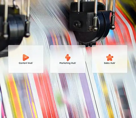 Trois icônes de hub de HubSpot : Content Hub, Marketing Hub et Sales Hub sont affichées sur un fond texturé d'impression