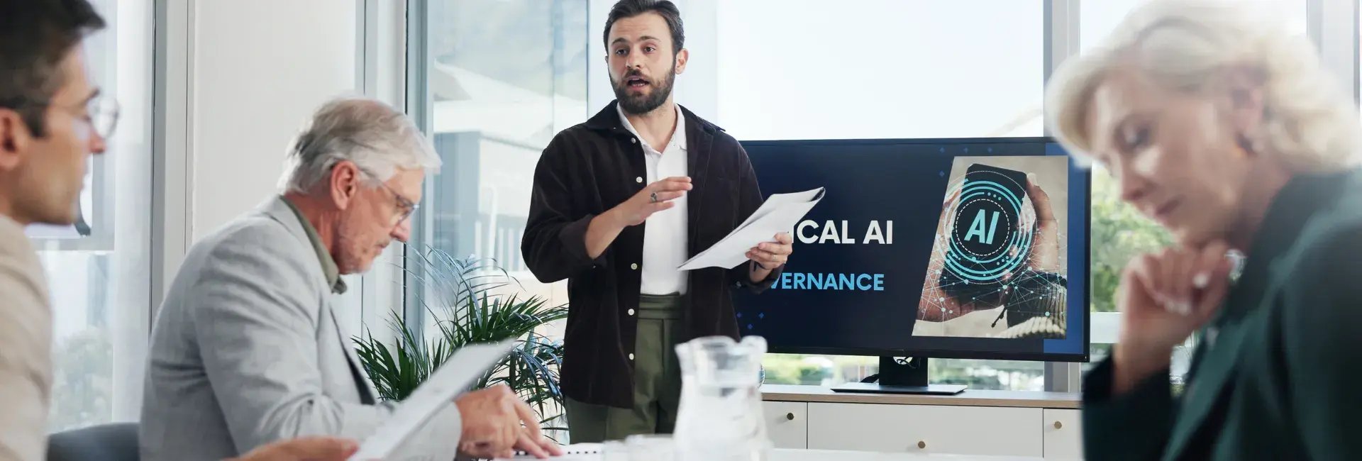 Un présentateur se tient devant un écran affichant « Gouvernance éthique de l'IA » lors d'une réunion d'affaires, captivant l'attention des participants.